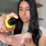 Femme appliquant le Trio Coco RoseBaie sur cheveux abîmés"